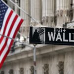 Wall Street sign with flag backdrop